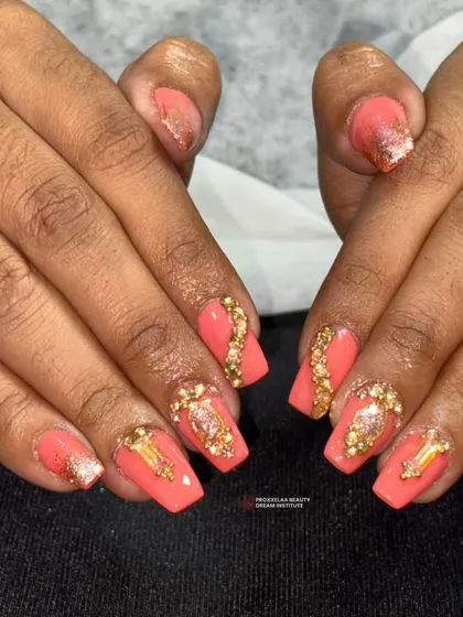 This angle shows the full set of the coral and gold jewel nails, demonstrating how the design is consistent yet unique across each finger.