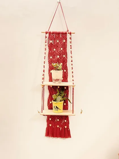 Here is the same two-tier red shelf design, styled with small plants to show how it can bring life to a plain wall. The double shelves offer ample space for a collection of small succulents or decorative objects.