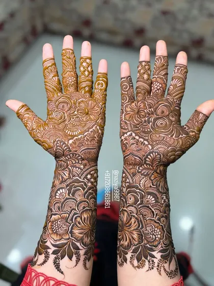 This design shows a mix of bold flowers on the forearm and more traditional, finer patterns on the palm.