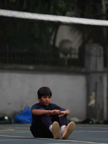 A young player sits and reflects after a drill. Even in quiet moments, the focus and love for the game are visible.