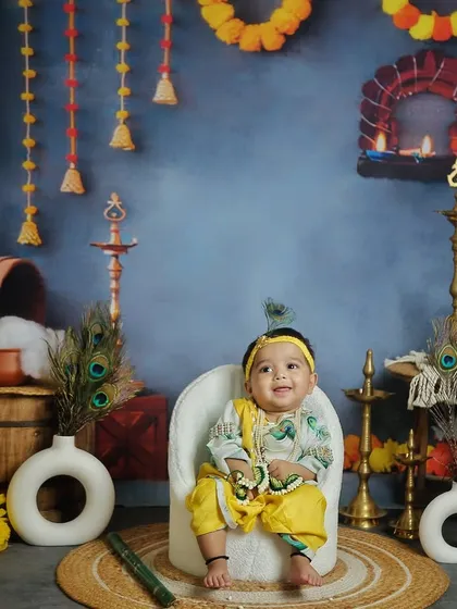 A smiling little Krishna from our Janmashtami-themed session. The traditional props like diyas and peacock feathers add an authentic touch.