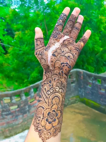 This full coverage bridal design features a beautiful flowing pattern with a mix of mandalas and floral work. The negative space creates a path, or 'sider', through the intricate design.