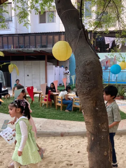 A bug-themed birthday party in full swing. The outdoor setting provides ample space for kids to run, play, and explore between activities like scavenger hunts and craft sessions.