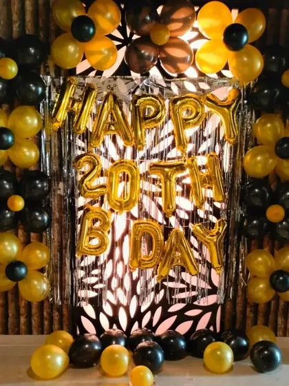 Another angle of the stylish 20th birthday setup. The combination of black and yellow balloons arranged like flowers against the shimmer curtain creates a very graphic and memorable backdrop.