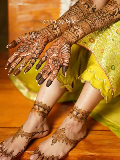 A complete bridal look, with intricate mehendi on both hands and feet, perfectly coordinated.