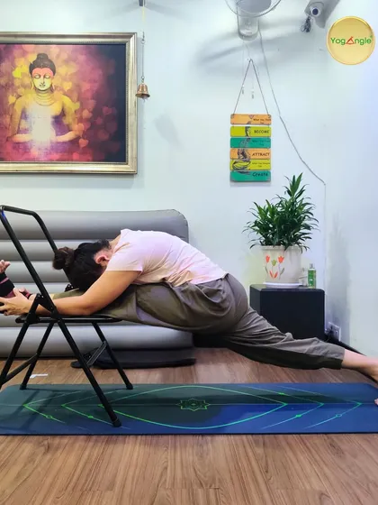 The Hanumanasana, or front split, is an advanced posture that requires significant hip flexibility. Using a chair for support allows for a gradual and safe progression into the full pose.
