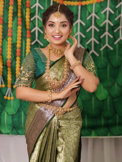 The bride's pose highlights the beautiful drape of the saree and the way the jewellery complements it.