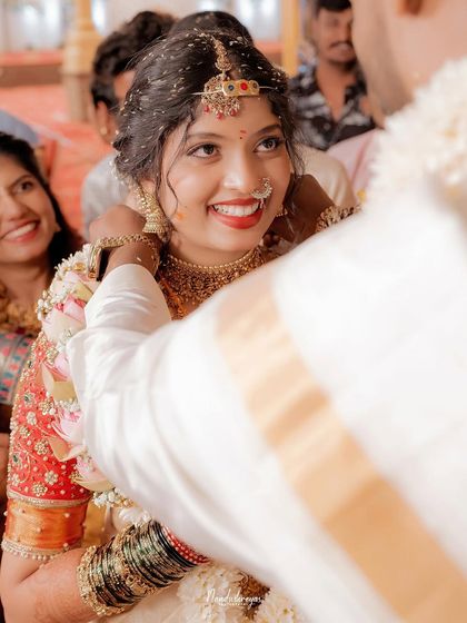 The bride’s radiant smile as the groom performs a ritual. Capturing this pure, uninhibited joy is what makes a wedding photograph truly timeless.