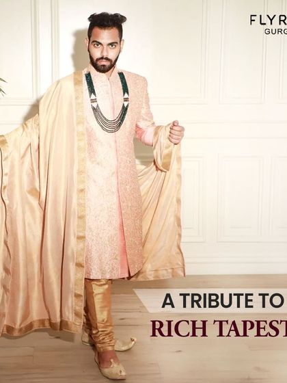A tribute to the rich tapestry of love. This model showcases a peach-colored sherwani with a flowing stole, an elegant and unique choice for a themed pre-wedding shoot.