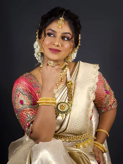 A graceful pose that highlights the waist belt (vaddanam) and the full set of temple jewellery, essential for an authentic South Indian bridal look.
