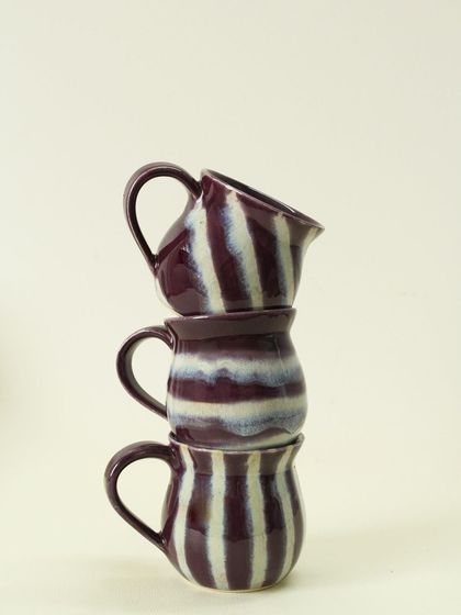 A playful stack of my Alluring Amethyst cups. The deep purple and white stripes are hand-painted, so each cup has its own unique rhythm and pattern.