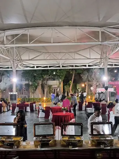 A wide shot of an evening reception we catered. The combination of buffet stations and guest seating under a large canopy shows our comprehensive event management capabilities.