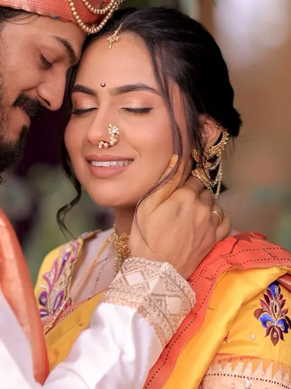An intimate moment between the bride and groom. Anchita's soft, neutral makeup looks serene and beautiful up close, highlighting her flawless skin and the delicate details of her nath.