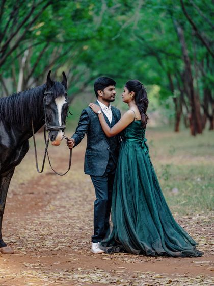 A romantic pose with a beautiful black horse in a lush green forest. This pre-wedding photo is straight out of a storybook.