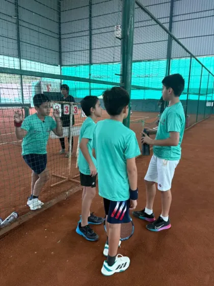 A team huddle during a doubles match to discuss strategy. Teamwork and communication are skills we emphasize on and off the court.