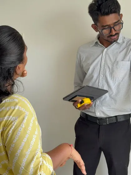 In discussion with a client, using a tablet to show design references and ideas during an early-stage site visit.