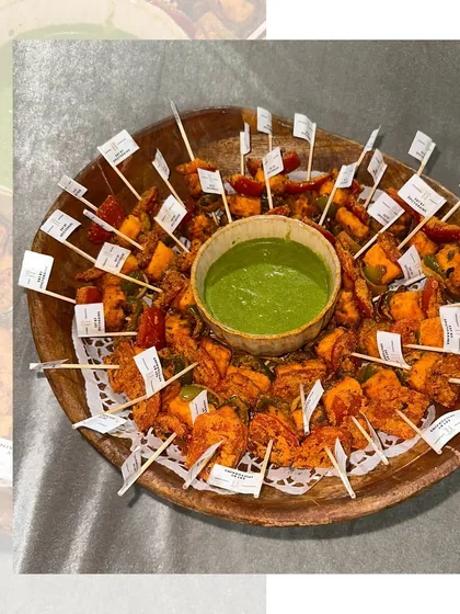 A platter of spicy paneer tikka skewers, ready to be served. The paneer is marinated in flavorful spices and grilled to perfection, making it a perennial favorite.