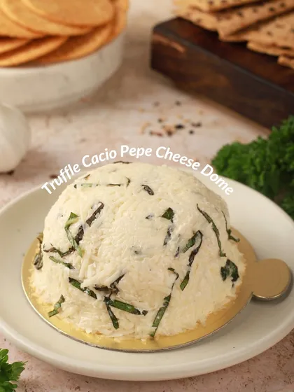 A closer look at our Truffle Cacio Pepe Cheese Dome. You can see the fresh herbs and cracked pepper blended into the creamy, truffle-infused cheese, perfect with simple crackers.