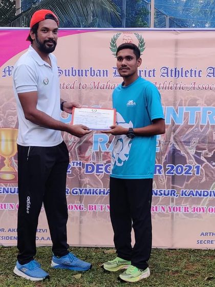 A coach presenting an award to one of our athletes for his achievement in the 10km open cross country race.