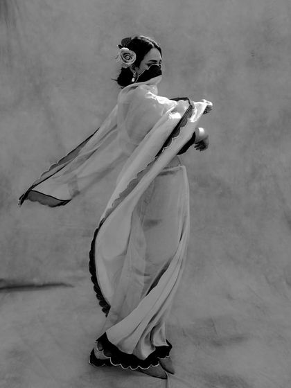 A full-length portrait captured on film, showing a model in motion. The flowing fabric and soft, diffused lighting create a graceful and dynamic composition suitable for fashion and artistic photography.