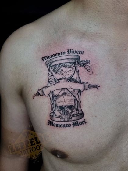A clearer, still image of the Memento Vivere, Memento Mori tattoo, showing the fine line work and shading on the chest.