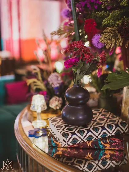 Another detail from the sangeet centerpiece, highlighting the texture of the vase and the custom-printed books used as decorative risers.