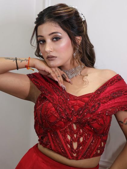 A confident pose from a client after her glam session. The makeup features a strong contour and a neutral lip, paired with a stylish half-up hairstyle.