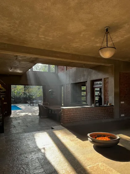 Sunlight streams into The Mango House, illuminating the raw textures of the brick and concrete. The home is designed to be a homestay, offering guests an experience of slow, sustainable living in a vernacular setting.