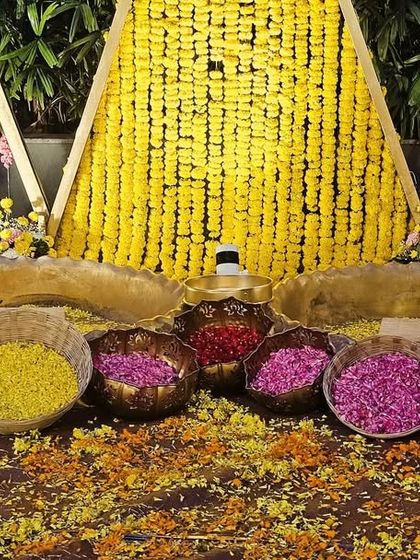 The details of a Haldi setup, showing bowls filled with colorful flower petals and turmeric, all arranged beautifully for the ceremony.