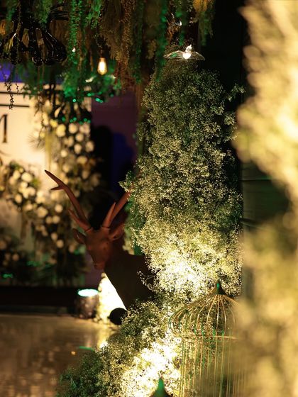 A fun little detail from our jungle-themed decor. A deer peeks out from behind a lush arrangement of baby's breath, adding a whimsical and surprising touch to the entrance passage.