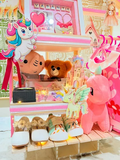 Cuddly soft toys, a personalized frame, and tiny shoes are nestled together in this whimsical first birthday hamper for little Varanya.