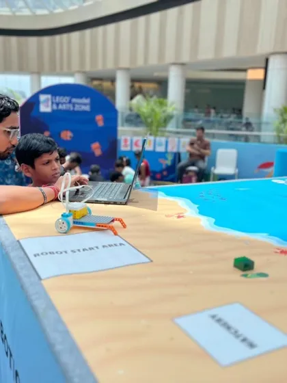 An instructor helps a young participant with his robot at our "Guardians of the Ocean" event at Forum Mall, showing how we make learning interactive and engaging for everyone.