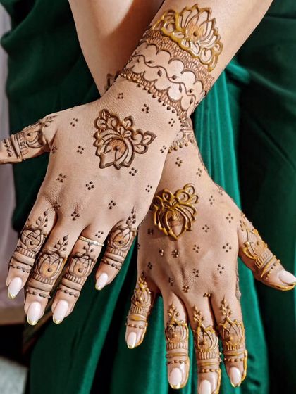 Simple but so elegant. This design features delicate lotus motifs on the palm and wrist, with tiny dots adding a touch of grace. The finger details complete this beautiful, understated look.