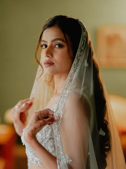 A close-up portrait of a bride, her delicate veil framing her face, capturing a moment of quiet beauty.