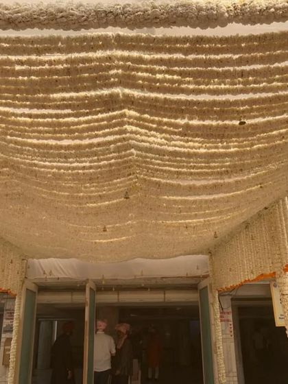 A close-up of the ceiling decor, where dense strings of white flowers create a fragrant and beautiful canopy. This kind of traditional floral work adds an authentic and sensory element to the celebration.