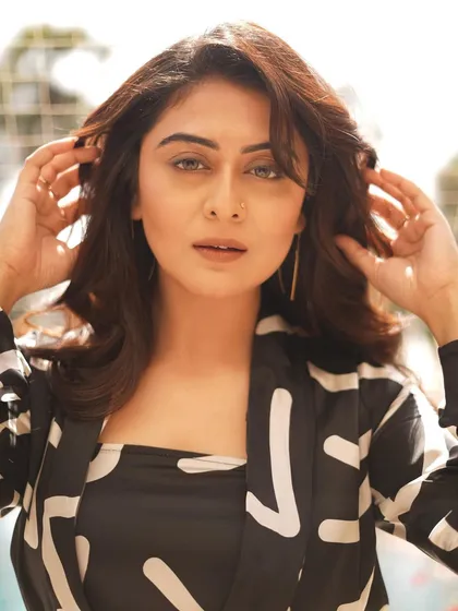 A striking portrait of actress Falaqnaazz, known for Biggboss OTT. Her direct gaze and the bold pattern of her outfit create a compelling and modern image.