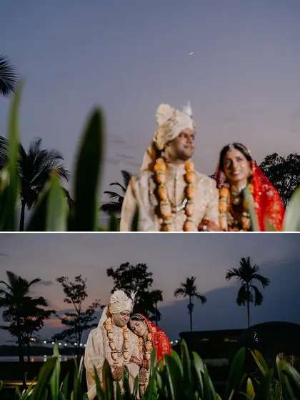 The couple shares a quiet moment together as dusk settles, with the twilight sky and palm trees creating a romantic, serene backdrop.