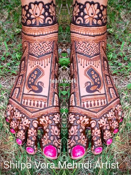 A beautiful foot design featuring peacocks within a geometric frame, with floral details on the toes. This was a team effort for a bridal party.