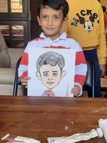 This little boy proudly holds his caricature, a unique and fun return gift that's much more personal than a standard party favor.