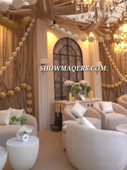 A plush lounge seating area for the Roka ceremony, decorated in soothing ivory and beige tones with elegant draping and floral ball garlands.