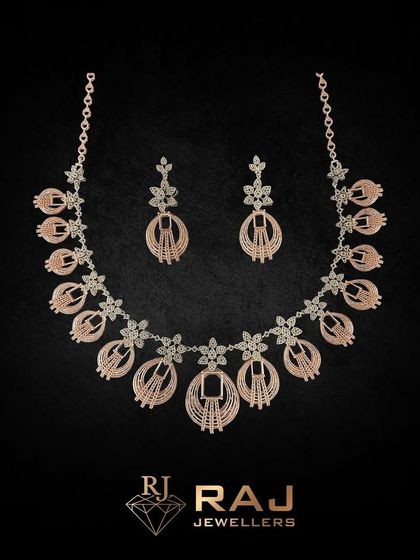 This intricate rose gold necklace set features beautifully detailed floral and oval motifs. The craftsmanship gives it a light, airy feel while providing significant sparkle and coverage.