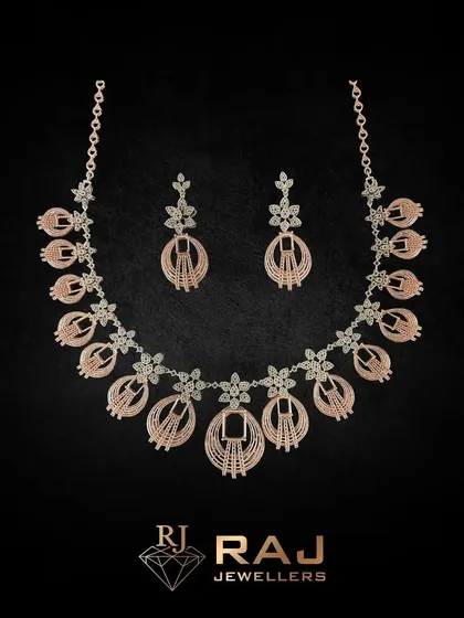 This intricate rose gold necklace set features beautifully detailed floral and oval motifs. The craftsmanship gives it a light, airy feel while providing significant sparkle and coverage.