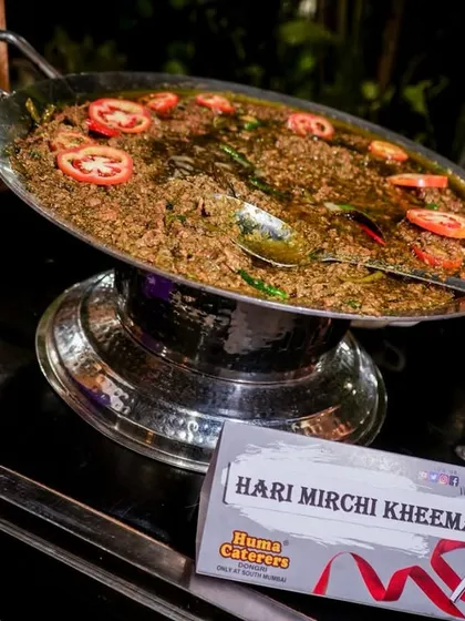 Our Hari Mirchi Kheema, a spicy and aromatic dish served from a live tawa station, garnished with fresh tomatoes.