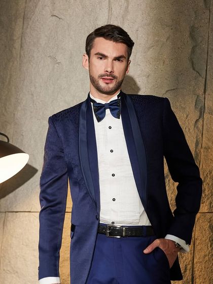 This shot of the navy tuxedo emphasizes its sharp cut and modern appeal. It's a versatile piece, perfect for a variety of formal events where you want to look distinguished.