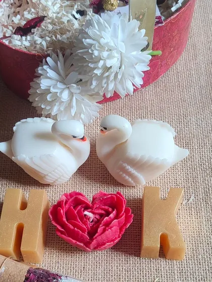 An anniversary hamper in the making. This set includes swan soaps, initial soaps, a heart-shaped candle, and bath salts.