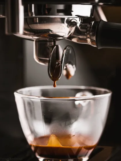 Another angle of the espresso pull, capturing the moment the first drop hits the cup. These action shots are compelling for any coffee-related brand.