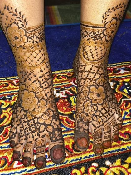 A lovely foot design featuring a net pattern (jaal) accented with bold flowers. The leafy vine around the ankle adds a delicate finishing touch.