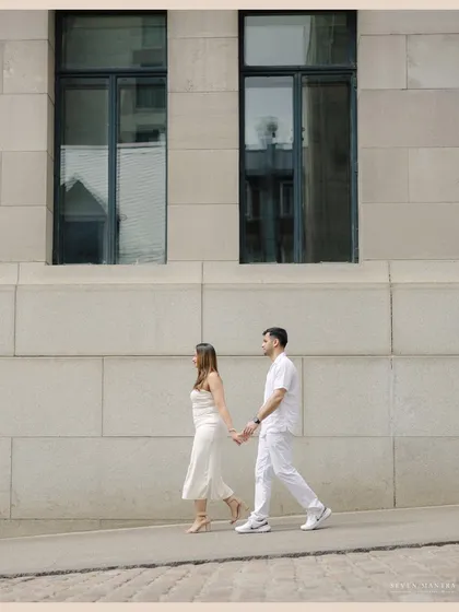 A quiet walk together, creating a simple and elegant frame. This minimalist shot from a Montreal pre-wedding session highlights the couple's connection against a clean, architectural background.