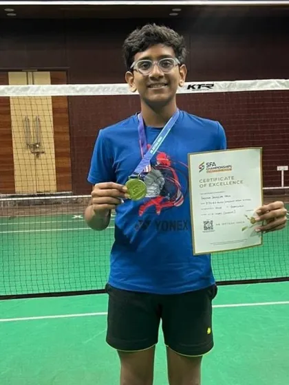 A closer look at Aarav Chettiar with his medals and certificate from the SFA Championship, representing his success in both singles and doubles.