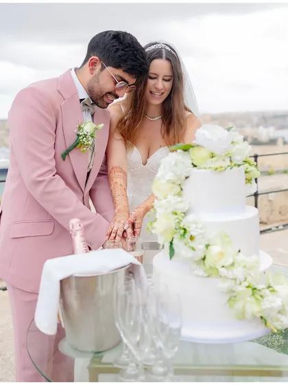 The couple cutting their beautiful, three-tiered wedding cake, a classic moment of celebration.